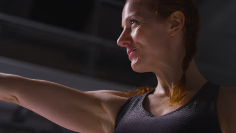 Portrait-Shot-Of-Mature-Smiling-Woman-Wearing-Gym-Fitness-Clothing-Exercising